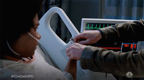 A Man Holds A Woman 'S Hand In Front Of A Monitor That Says Nbc GIF