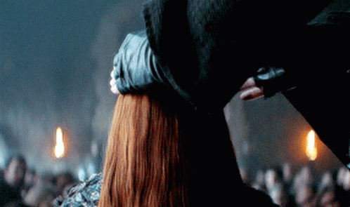 A Man Holds A Woman 'S Head In A Dark Room GIF