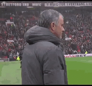 A Man Holds His Finger To His Mouth While Standing On A Field GIF