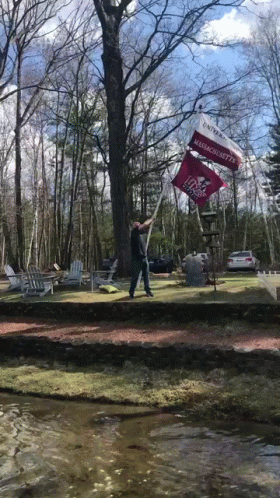 a man holds up a flag that says massachusetts on it
