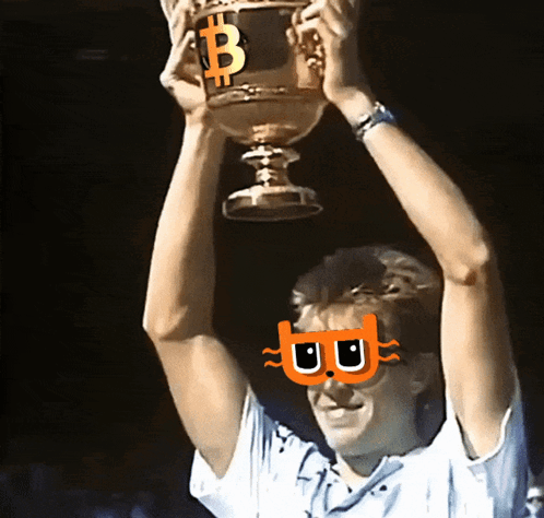 A Man Holds Up A Trophy With A Bitcoin Symbol On It GIF