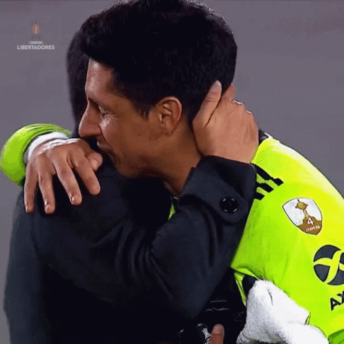 A Man Hugging Another Man With The Word Libertadores In The Corner GIF