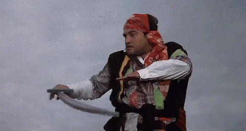 a man in a bandana is holding a rope and pointing at something .