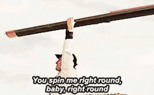 A Man In A Baseball Cap Is Holding His Arms Up In The Air While Singing A Song . GIF