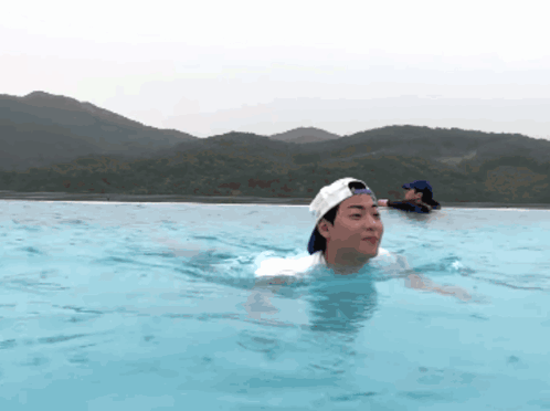 A Man In A Baseball Cap Is Swimming In A Pool GIF
