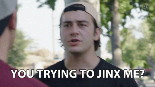 a man in a baseball cap is talking to another man and says you trying to jinx me