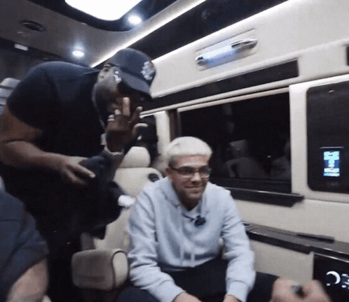 a man in a baseball cap is talking to another man in a car