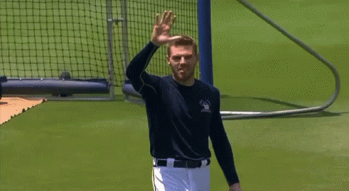 A Man In A Baseball Uniform Is Waving His Hand In The Air GIF