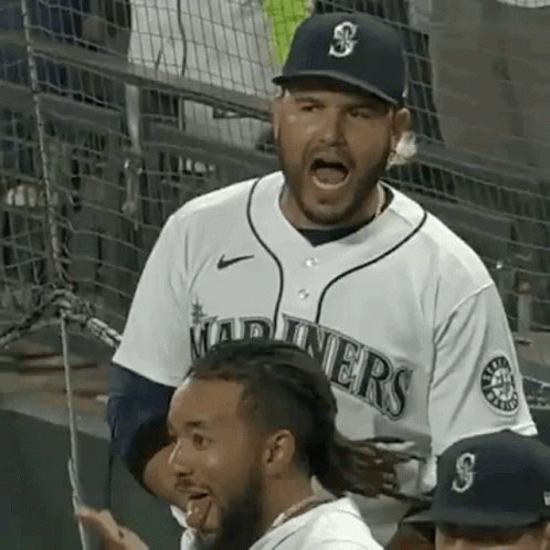 A Man In A Baseball Uniform Is Yelling At Another Man In A Stadium . GIF
