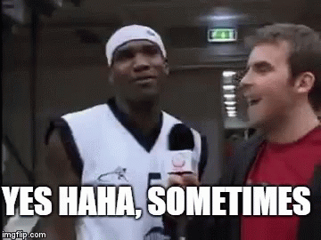 A Man In A Basketball Jersey Is Talking To A Man In A Red Shirt While Holding A Microphone . GIF