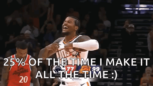 A Man In A Basketball Uniform Is Holding A Basketball And Laughing While Another Man Stands Behind Him . GIF