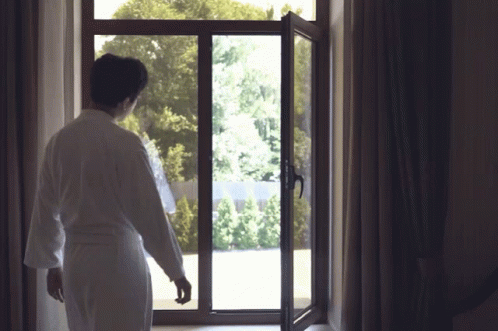 Man In Bathrobe Looking Out Window GIF