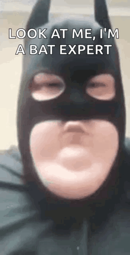 A Man In A Batman Costume Is Making A Funny Face . GIF