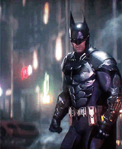 a man in a batman costume is walking down a street at night