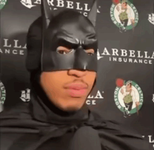 Man In Batman Mask Standing In Front Of Celtics Sign GIF