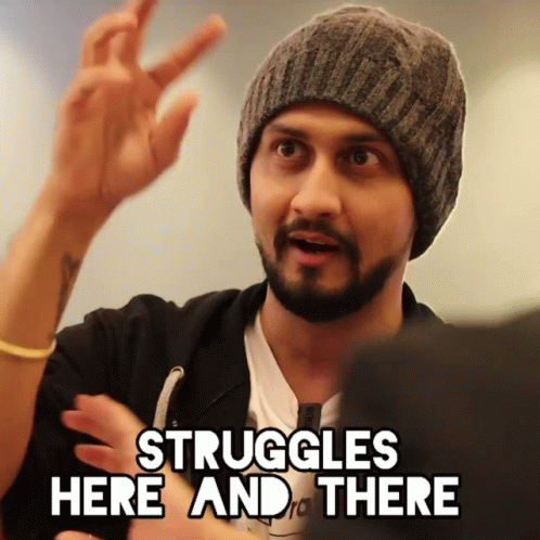 A Man In A Beanie Says " Struggles Here And There " With His Hand GIF