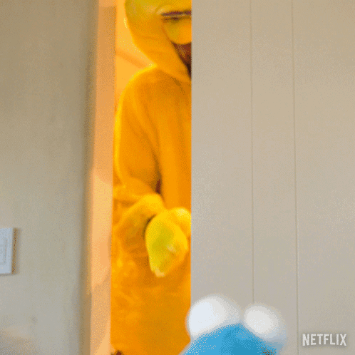 A Man In A Big Bird Costume Is Standing Next To A Netflix Sign GIF