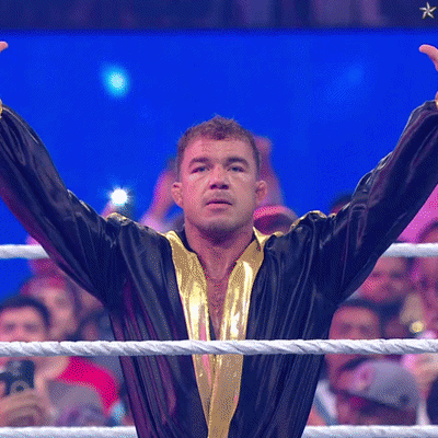 A Man In A Black And Gold Robe Stands In A Boxing Ring GIF