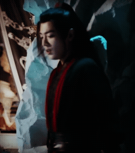 A Man In A Black And Red Costume Is Standing In The Dark GIF