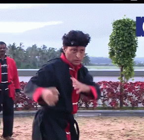 A Man In A Black And Red Karate Uniform Stands In Front Of A Sign That Says ' Ntv ' GIF