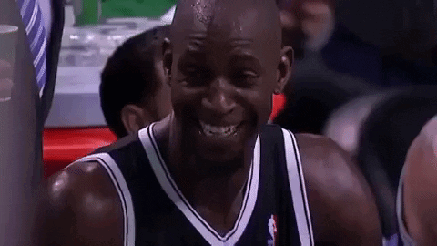 A Man In A Black And White Jersey Is Smiling GIF