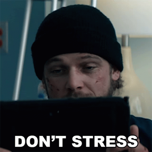 A Man In A Black Beanie Is Looking At A Tablet With The Words " Do N't Stress " On The Bottom GIF