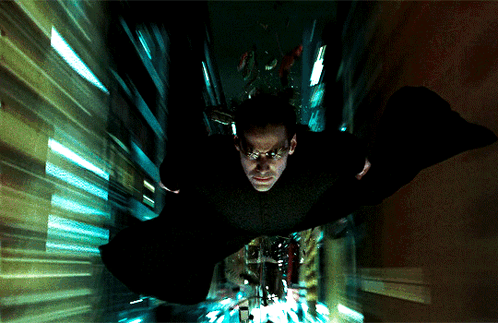 A Man In A Black Cape Is Flying Through A Tunnel GIF
