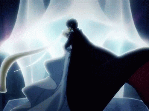 A Man In A Black Cape Is Standing Next To A Woman In A White Gown GIF