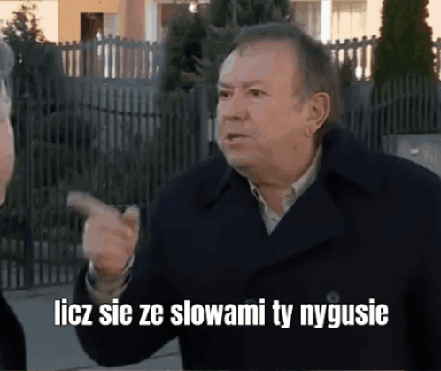 A Man In A Black Coat Is Pointing With The Words Liczy Sie Ze Slowami Ty Nygusie GIF