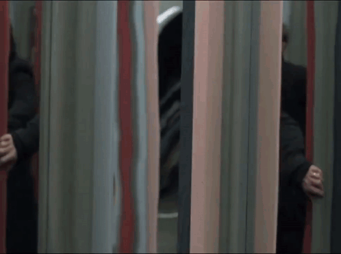 A Man In A Black Coat Is Running Through A Mirrored Room GIF