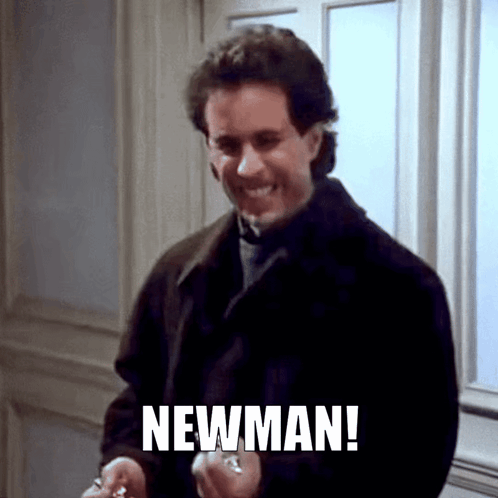 A Man In A Black Coat Is Smiling And Holding A Key And The Word Newman Is On The Bottom Of The Picture GIF