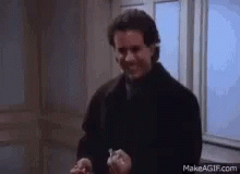 A Man In A Black Coat Is Smiling While Holding A Bottle Of Pills . GIF