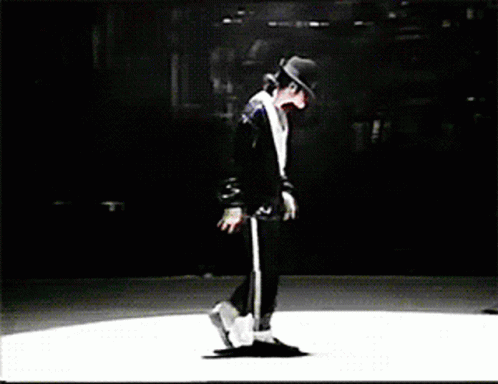 A Man In A Black Hat Is Dancing On A White Stage GIF