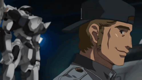 A Man In A Black Hat Is Smiling In Front Of A Robot GIF