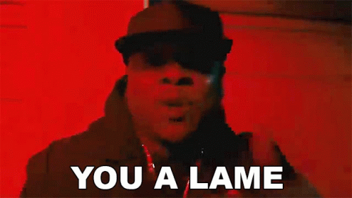 A Man In A Black Hat Is Standing In Front Of A Red Wall And Saying `` You A Lame '' . GIF
