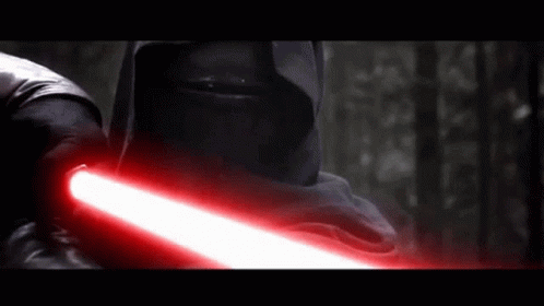 A Man In A Black Hood Is Holding A Red Lightsaber GIF