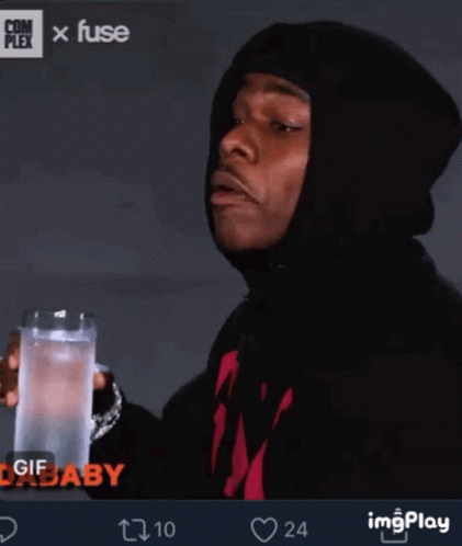 A Man In A Black Hoodie Is Holding A Glass Of Water In His Hand GIF