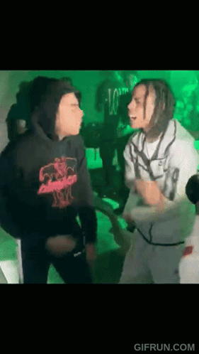 A Man In A Black Hoodie Is Standing Next To A Man In A White Shirt . GIF
