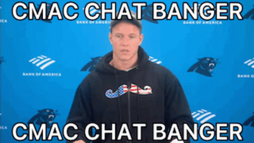 A Man In A Black Hoodie Stands In Front Of A Blue Wall With Panthers On It GIF