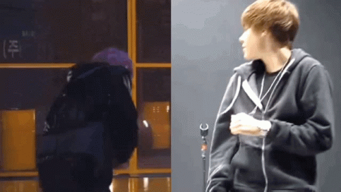 A Man In A Black Hoodie Stands Next To A Microphone GIF