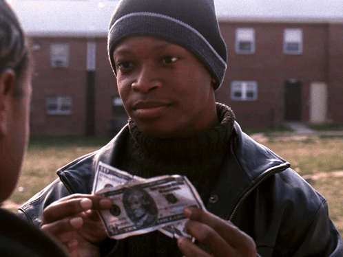 A Man In A Black Jacket Holds Up A 10 Dollar Bill GIF