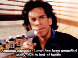 A Man In A Black Jacket Is Holding A Microphone And Says Attention Campers GIF