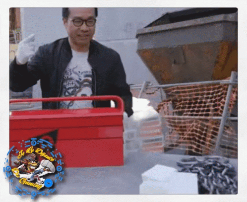 A Man In A Black Jacket Is Holding A Red Toolbox With A Picture Of A Monkey On The Bottom Right GIF