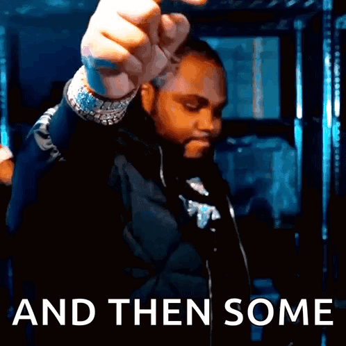 A Man In A Black Jacket Is Holding His Fist Up In Front Of The Words And Then Some GIF