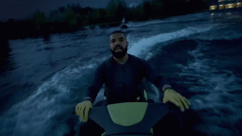 A Man In A Black Jacket Is Riding A Jet Ski GIF