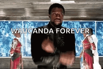 A Man In A Black Jacket Is Standing In Front Of A Chalkboard With The Words Waucunda Forever Written On It . GIF