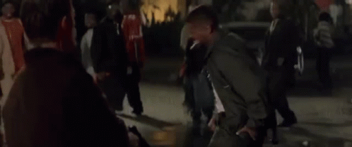 A Man In A Black Jacket Is Standing In Front Of A Crowd Of People And Says You Motherfucker . GIF