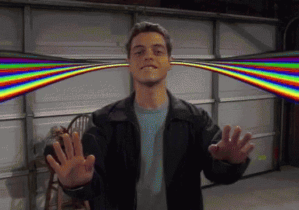 A Man In A Black Jacket Is Standing In Front Of A Garage Door With A Rainbow Behind Him GIF