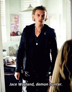 A Man In A Black Jacket Is Standing Next To A Woman And Says Jace Wayland Demon Hunter . GIF