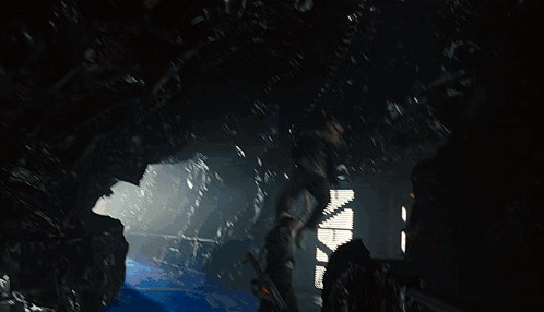 A Man In A Black Jacket Is Standing On A Blue Surface GIF